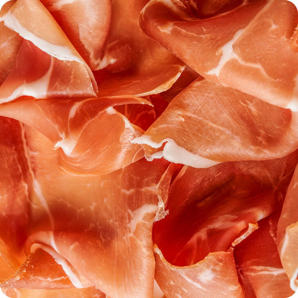 Una vista dall'alto di tante fette di prosciutto.