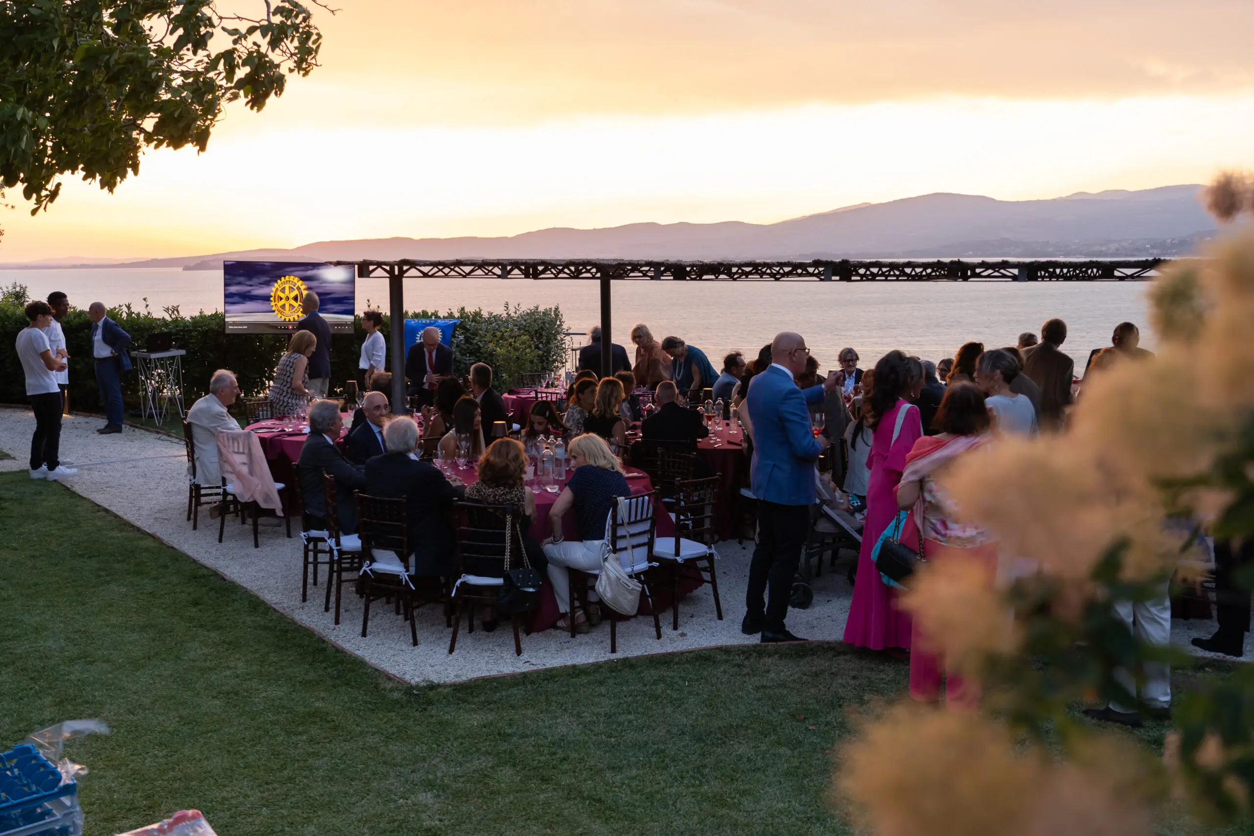 Persone a cena in una location con vista sul lago Trasimeno